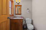 This charming bathroom features a rustic wooden vanity with a white sink and a chrome faucet, complemented by a matching wooden mirror frame.