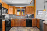 This charming kitchen features warm, natural wood cabinetry complemented by elegant granite countertops.