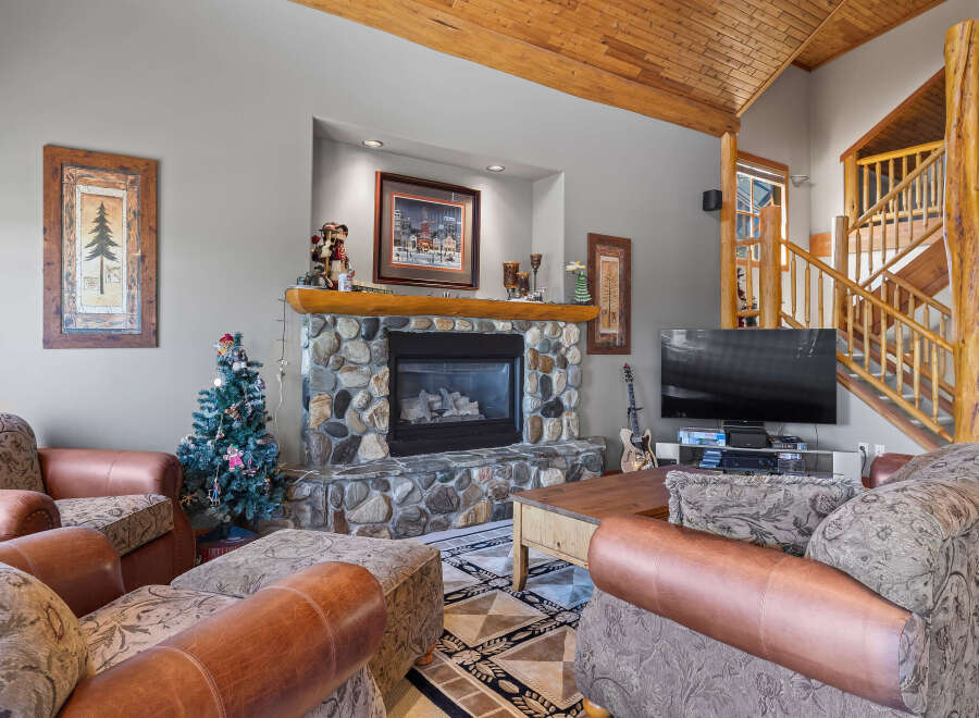 Cozy up by the stone fireplace in this inviting living room, perfect for gathering with loved ones.