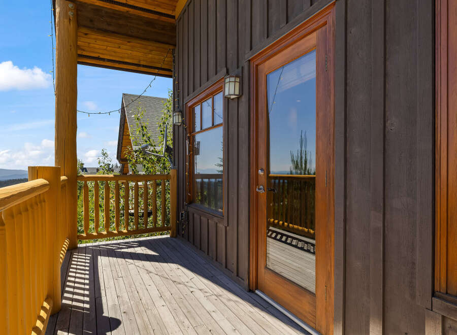 Enjoy breathtaking mountain views from this charming log cabin's expansive deck.