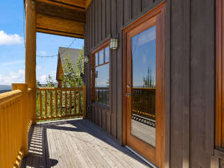 Enjoy breathtaking mountain views from this charming log cabin's expansive deck.