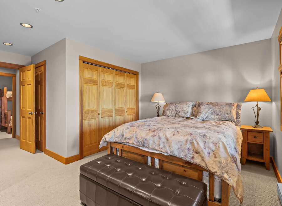 This inviting bedroom features a comfortable queen-size bed adorned with a floral comforter and matching pillows, creating a cozy atmosphere.