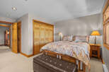 This inviting bedroom features a comfortable queen-size bed adorned with a floral comforter and matching pillows, creating a cozy atmosphere.