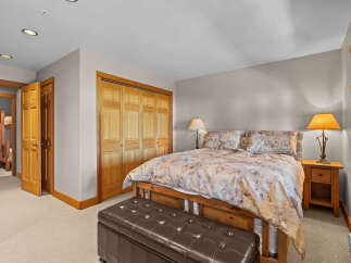 This inviting bedroom features a comfortable queen-size bed adorned with a floral comforter and matching pillows, creating a cozy atmosphere.