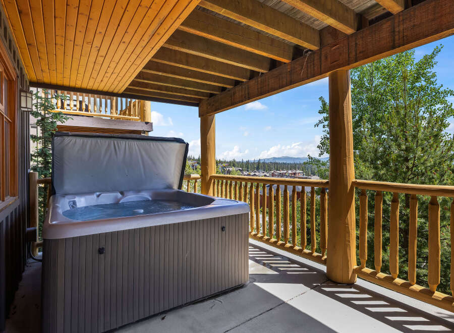Enjoy ultimate relaxation on this covered deck featuring a spacious hot tub with stunning mountain views.