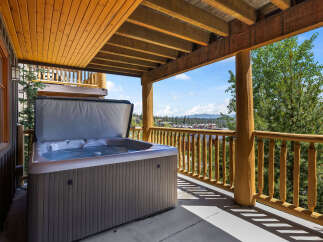 Enjoy ultimate relaxation on this covered deck featuring a spacious hot tub with stunning mountain views.