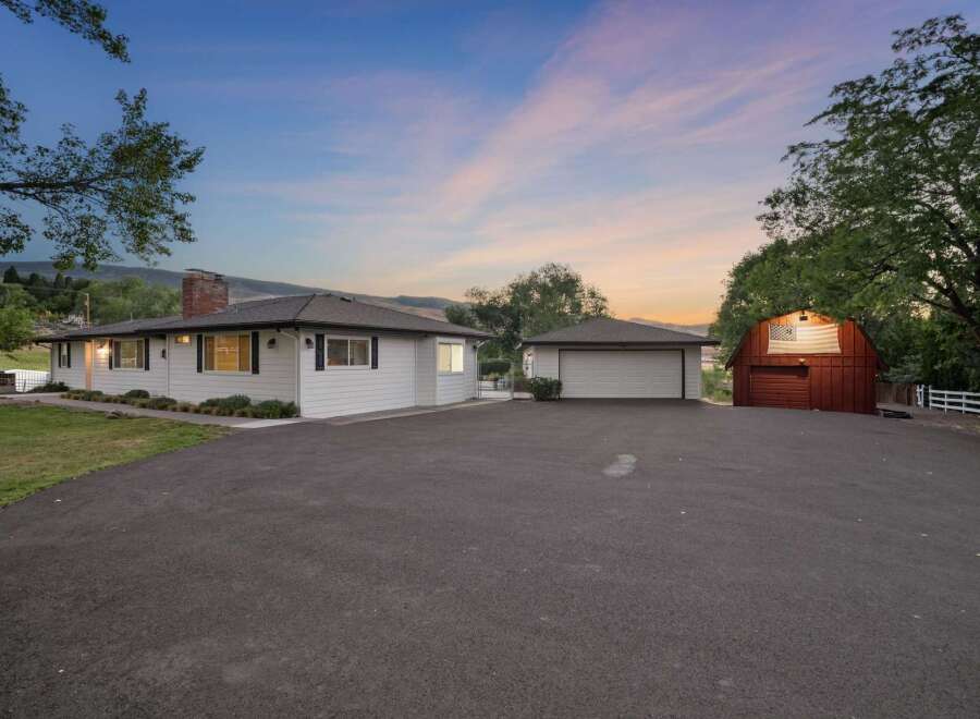 Discover this charming property featuring a well-maintained home with a classic brick chimney and black shutters, complemented by a spacious two-car garage.