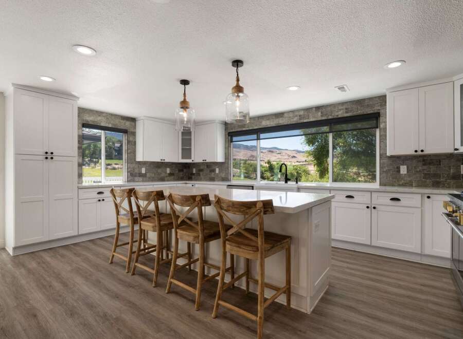 Experience breathtaking views from this stunning kitchen, featuring a large island perfect for entertaining and white shaker cabinets offering ample storage.