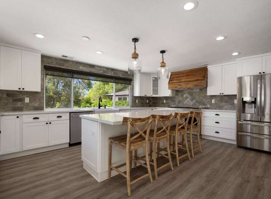 Experience modern luxury in this stunning kitchen, featuring crisp white cabinetry, elegant quartz countertops, and a striking herringbone tile backsplash.