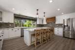 Experience modern luxury in this stunning kitchen, featuring crisp white cabinetry, elegant quartz countertops, and a striking herringbone tile backsplash.