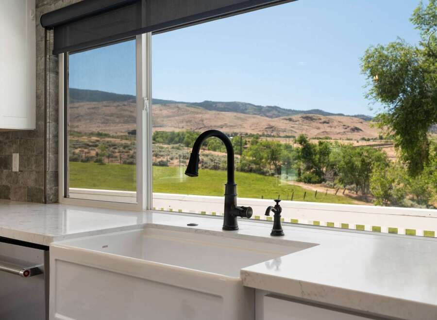 Experience breathtaking views from this stunning kitchen, featuring a large farmhouse sink and elegant marble countertops.