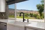 Experience breathtaking views from this stunning kitchen, featuring a large farmhouse sink and elegant marble countertops.