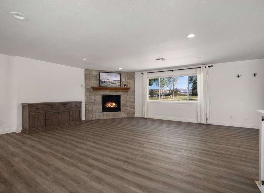Experience comfort and style in this spacious living area, featuring a charming stone fireplace perfect for cozy evenings.