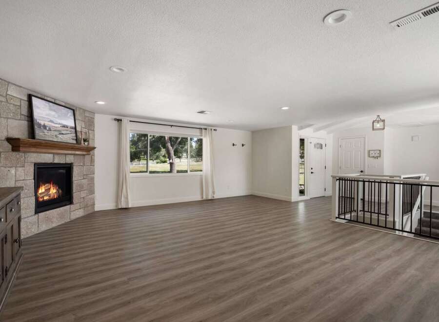 Step into this inviting living space featuring a striking stone fireplace, perfect for cozy evenings.