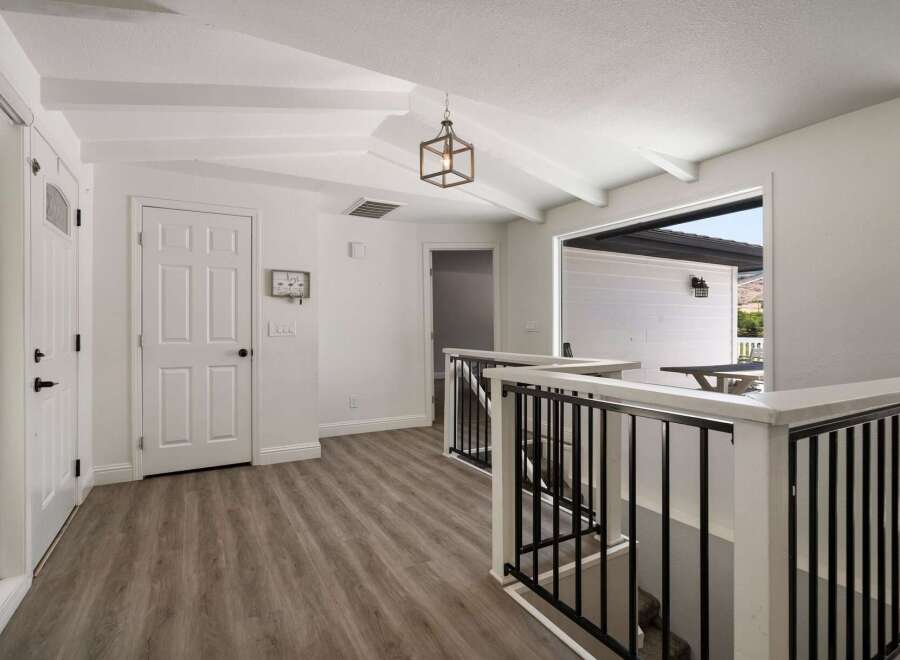 Step into this charming home featuring a bright and airy entryway with vaulted ceilings and exposed beams.