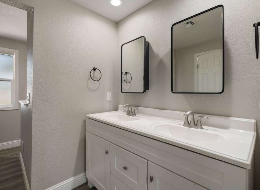 This modern bathroom features a spacious double vanity with two sinks and sleek silver faucets, perfect for busy mornings.