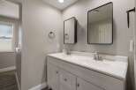 This modern bathroom features a spacious double vanity with two sinks and sleek silver faucets, perfect for busy mornings.