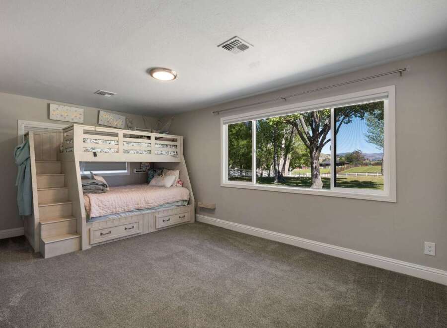 This charming bedroom features a space-saving bunk bed with built-in drawers, perfect for maximizing storage.