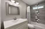 This modern bathroom features a sleek white vanity with a matching sink and a brushed nickel faucet.