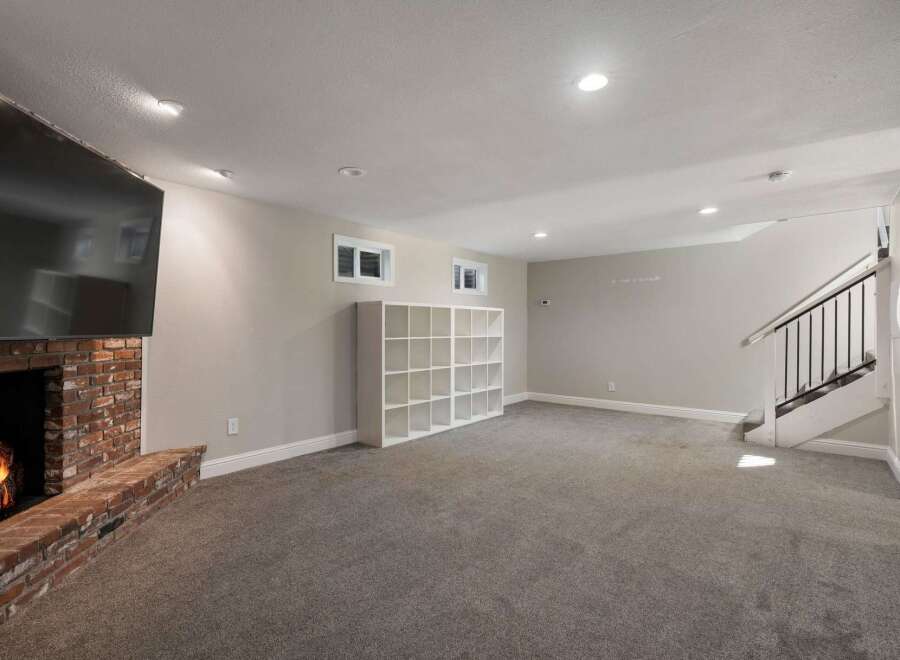 Cozy up by the brick fireplace in this spacious living area, perfect for relaxation and entertainment.