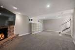 Cozy up by the brick fireplace in this spacious living area, perfect for relaxation and entertainment.