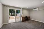 This spacious room features a large sliding glass door that opens to a serene outdoor space, perfect for enjoying the natural surroundings.