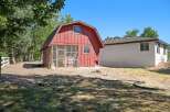 Discover this charming property featuring a unique red barn with a screened enclosure, perfect for outdoor living or animal housing.