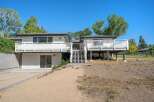 Discover this stunning multi-level home featuring expansive white decks perfect for outdoor entertaining and enjoying the scenic surroundings.