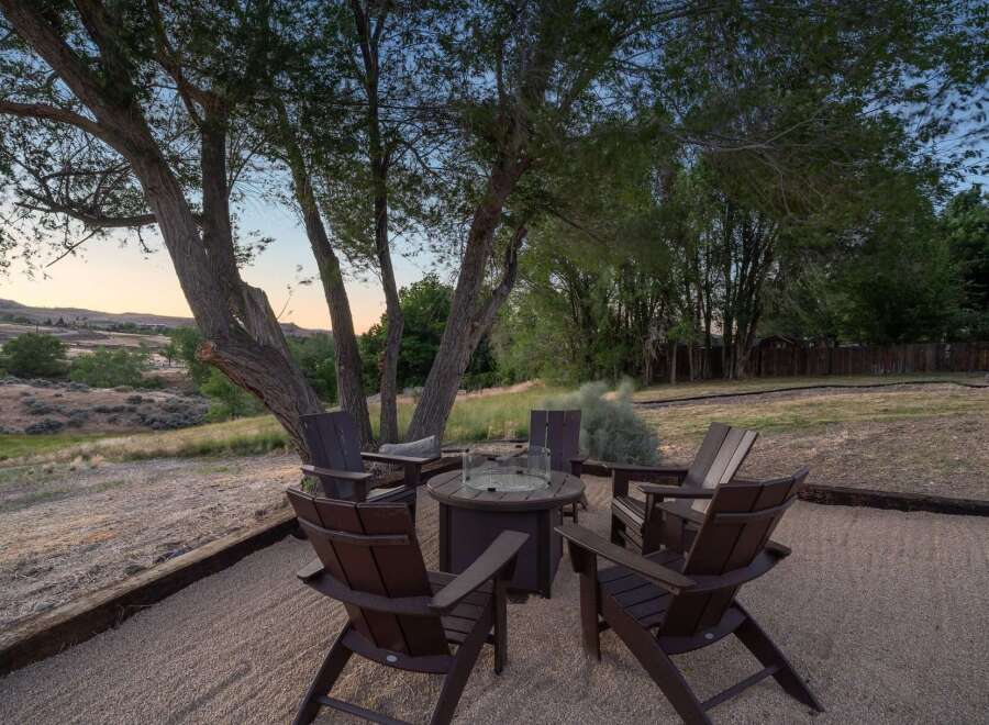 Gather around the fire pit in this inviting outdoor seating area, perfect for enjoying cool evenings under the stars.