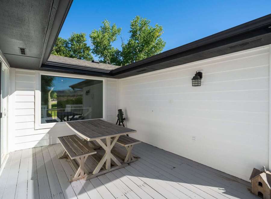 Enjoy outdoor living on this charming deck, complete with a rustic picnic table and benches perfect for al fresco dining.