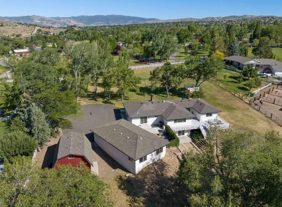 Discover this expansive property featuring a spacious main residence and a charming red barn, perfect for equestrian enthusiasts.