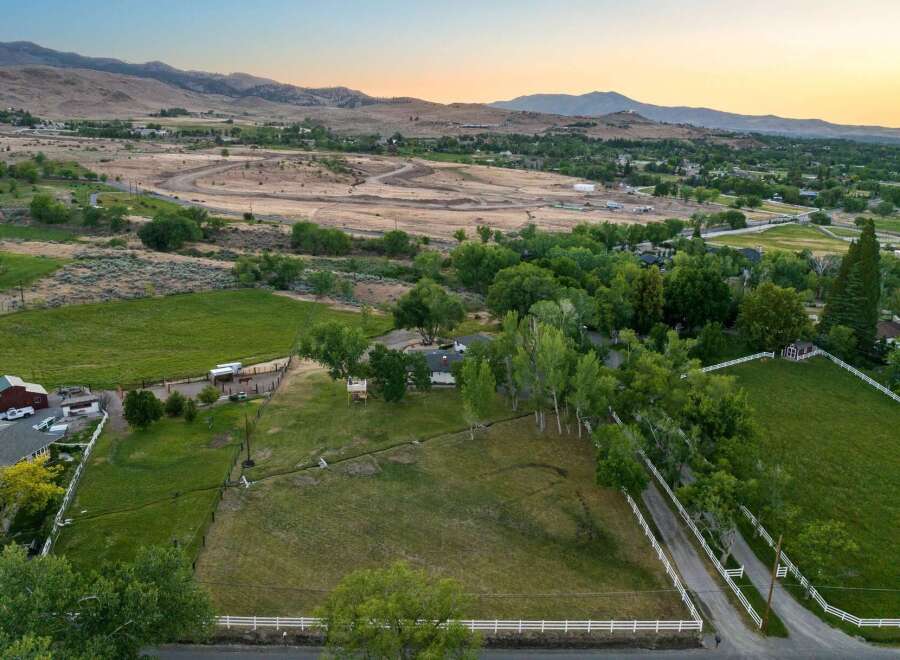 Discover this expansive rural property offering a blend of open green pastures and mature trees, perfect for equestrian activities or a serene retreat.