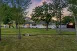 Discover this charming white ranch-style home nestled on a sprawling property, perfect for outdoor enthusiasts.