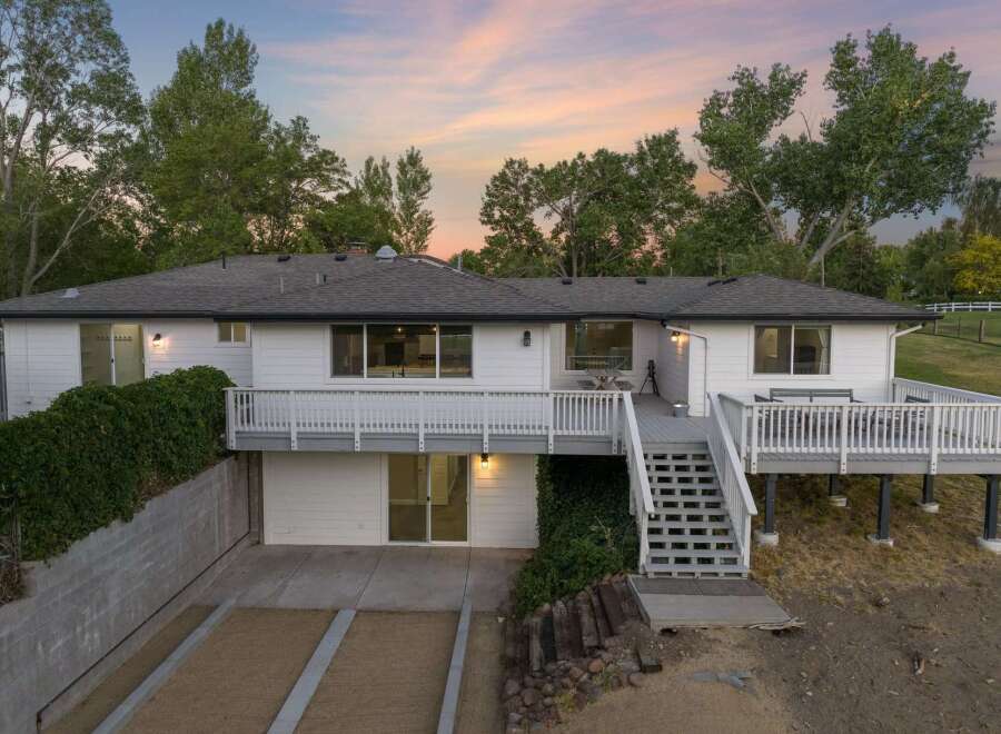 Discover this charming white home featuring a spacious multi-level deck perfect for outdoor entertaining.