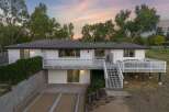 Discover this charming white home featuring a spacious multi-level deck perfect for outdoor entertaining.