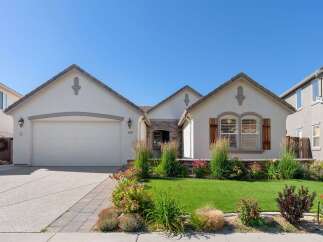 Charming single-family home featuring a well-maintained lawn and vibrant landscaping.