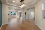 Step into this beautifully appointed living space, featuring gleaming hardwood floors and an elegant tray ceiling with recessed lighting.