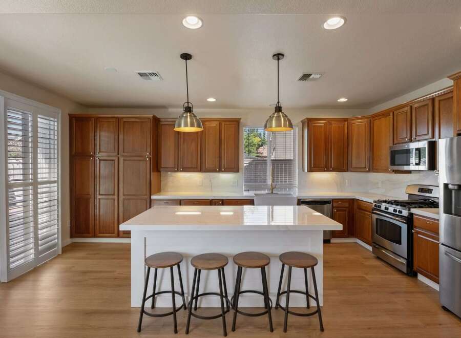 Experience the heart of this home with a spacious kitchen featuring rich wood cabinetry and a large island perfect for entertaining.