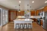 Experience the heart of this home with a spacious kitchen featuring rich wood cabinetry and a large island perfect for entertaining.