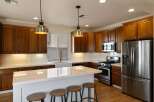 Experience culinary excellence in this stunning kitchen, featuring rich wood cabinetry and a sleek white quartz island perfect for entertaining.