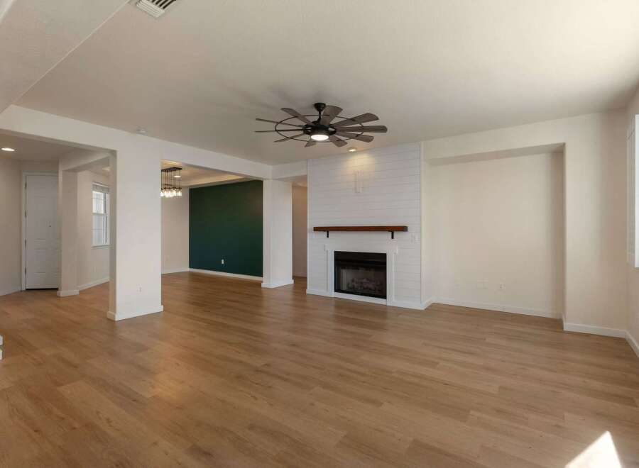 Experience modern living in this spacious open-concept home featuring a striking fireplace with shiplap accent and a rustic wood mantel.