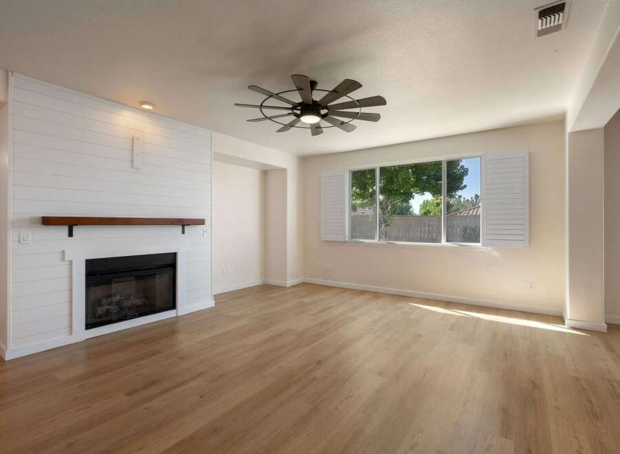 Experience modern living in this beautifully appointed living room, featuring a striking white shiplap fireplace with a rustic wood mantel.