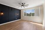 Experience modern living in this stylish room featuring a dramatic black accent wall with geometric paneling and elegant sconce lighting.