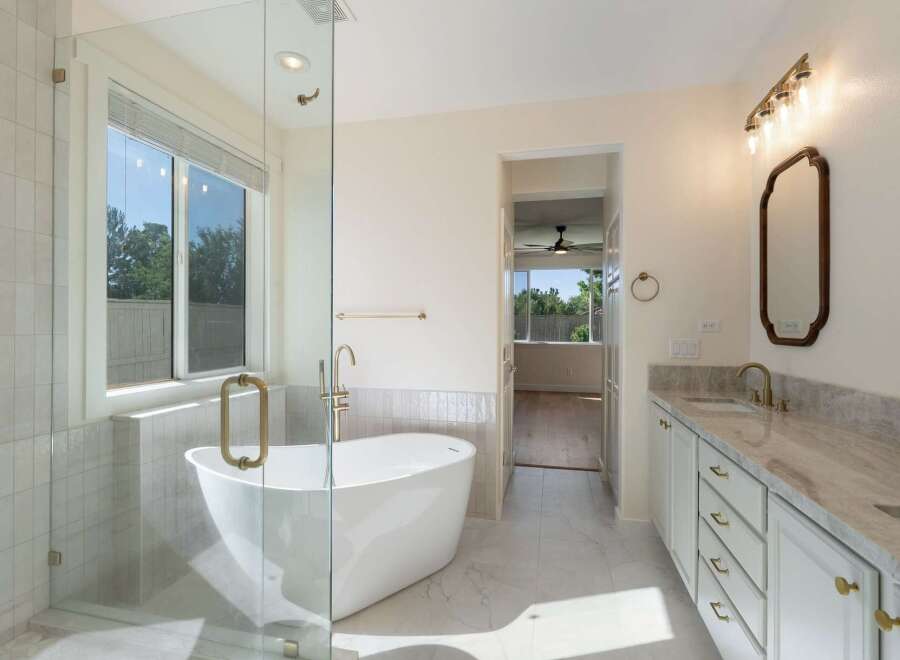 Indulge in luxury with this stunning bathroom featuring a freestanding soaking tub and a spacious glass-enclosed shower.