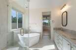 Indulge in luxury with this stunning bathroom featuring a freestanding soaking tub and a spacious glass-enclosed shower.