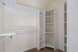Discover ample storage in this spacious walk-in closet, featuring a versatile shelving system and multiple hanging rods.