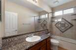 This bathroom features a granite countertop with an ornate mosaic tile backsplash, complemented by a white undermount sink and chrome fixtures.