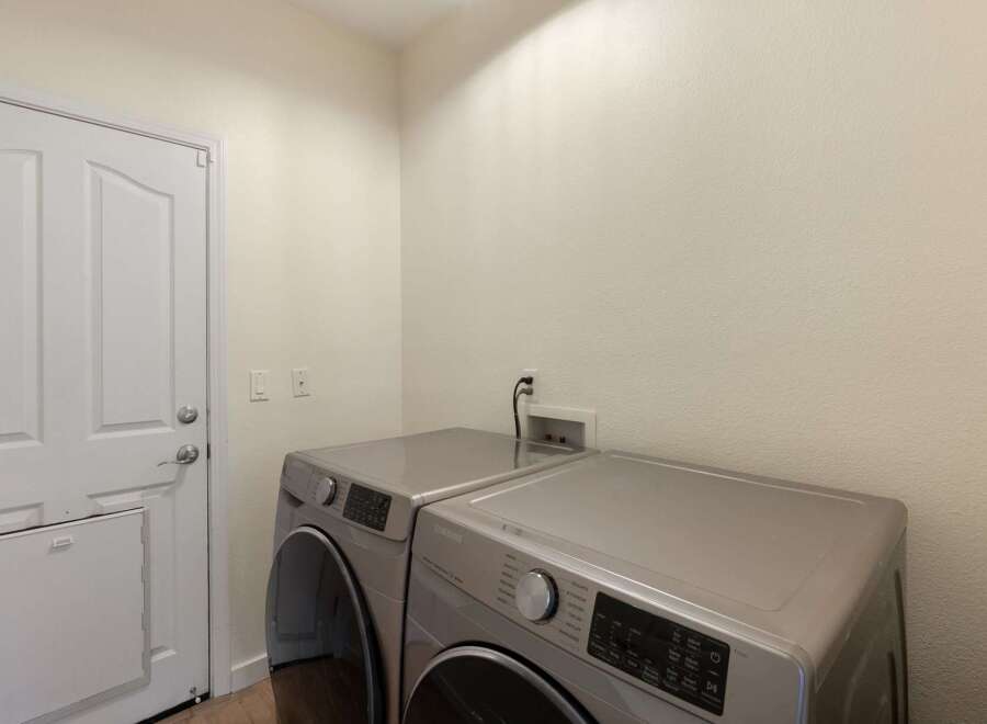 Discover a functional laundry room featuring a modern Samsung washer and dryer set, perfect for handling your household needs.