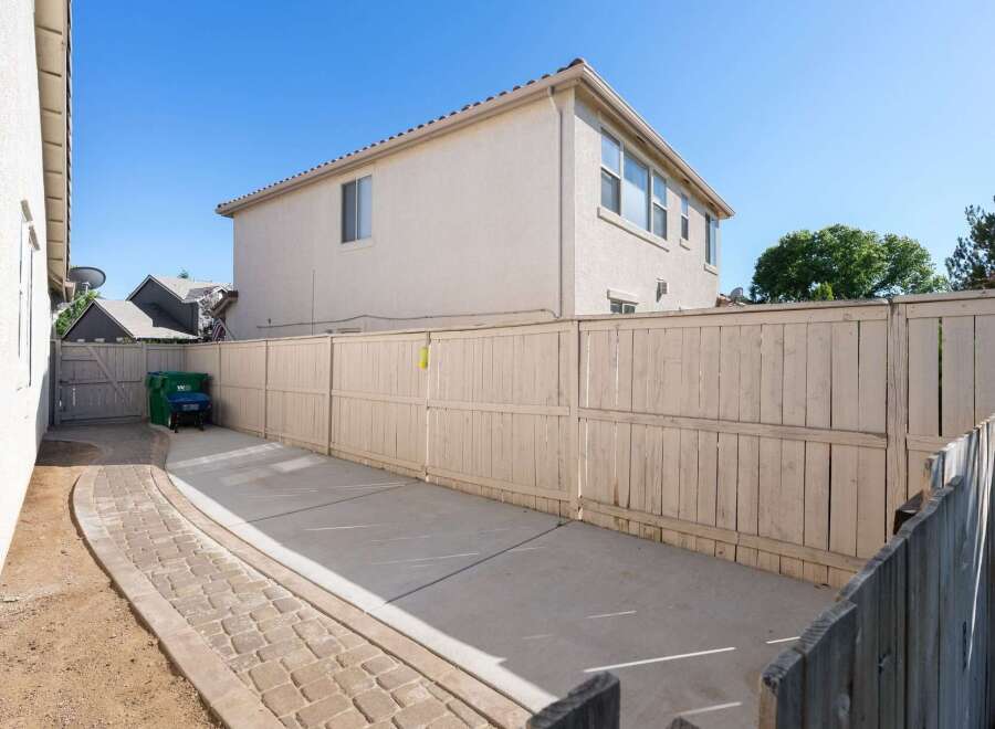 Discover the potential of this spacious backyard, featuring a paved walkway leading to a concrete patio area perfect for outdoor entertaining.