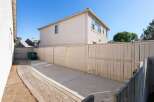 Discover the potential of this spacious backyard, featuring a paved walkway leading to a concrete patio area perfect for outdoor entertaining.